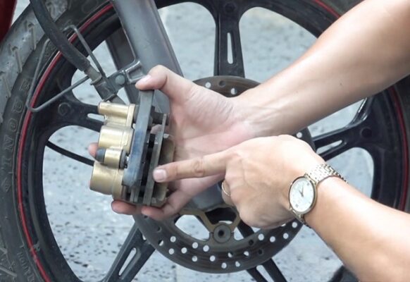 Xịt nước vào các lỗ nhỏ trong heo dầu phanh xe máy để loại bỏ bụi bẩn khắc phục tình trạng bị kêu